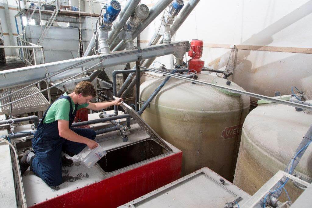 Kelder leegt de maatbeker vol entstof in één van de zes mengtanks in de brijvoerkeuken. De aangemaakte hoeveelheid is goed voor twee voerbeurten, een dag later volgt hetzelfde recept. 